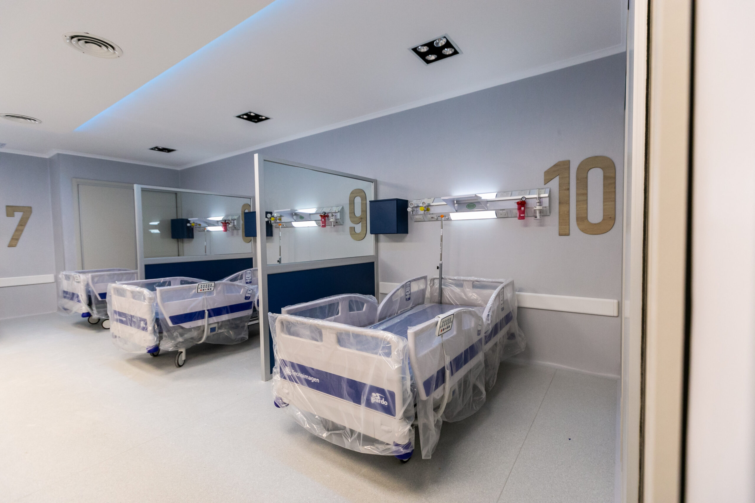 Sala de internación con camas, cabeceros y equipamiento hospitalario instalado