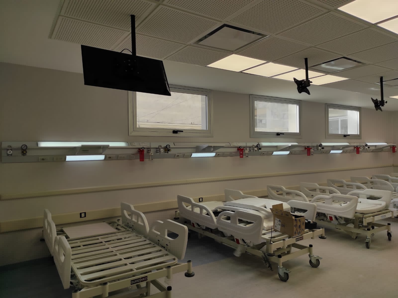 Vista de una sala hospitalaria con una red de cabeceros sobre las camas
